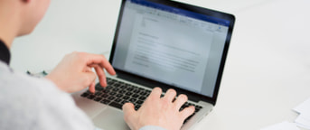 Mitarbeiter arbeitet an Laptop Mitarbeiter arbeitet an Laptop